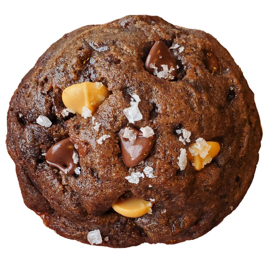 Chocolate cookie with caramel bits and sea salt on a white background