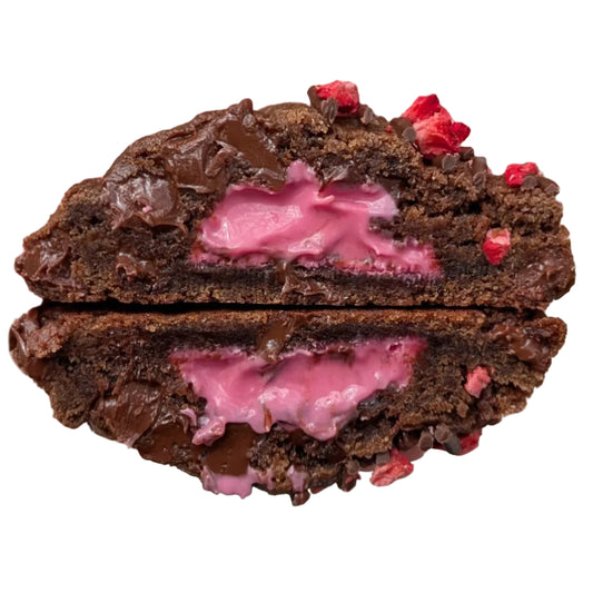 A dark chocolate cookie cut in half to show a pink strawberry cream filling, with chocolate chips and dried strawberry pieces on top, isolated on a white background.