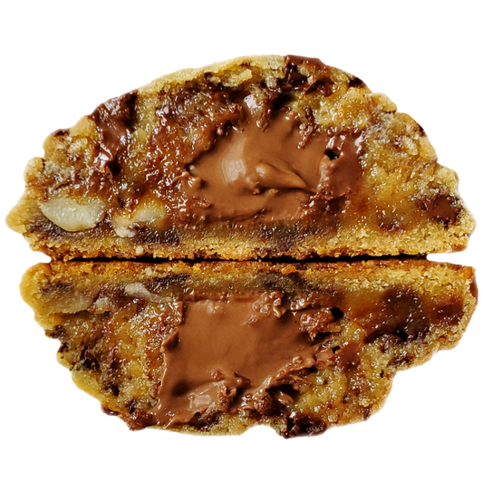 A close-up of a nutella-filled cookie cut in half vertically, showing a thick layer of glossy brown nutella spread inside a golden-brown cookie with darker chocolate chips and chopped hazelnuts, on a white background.
